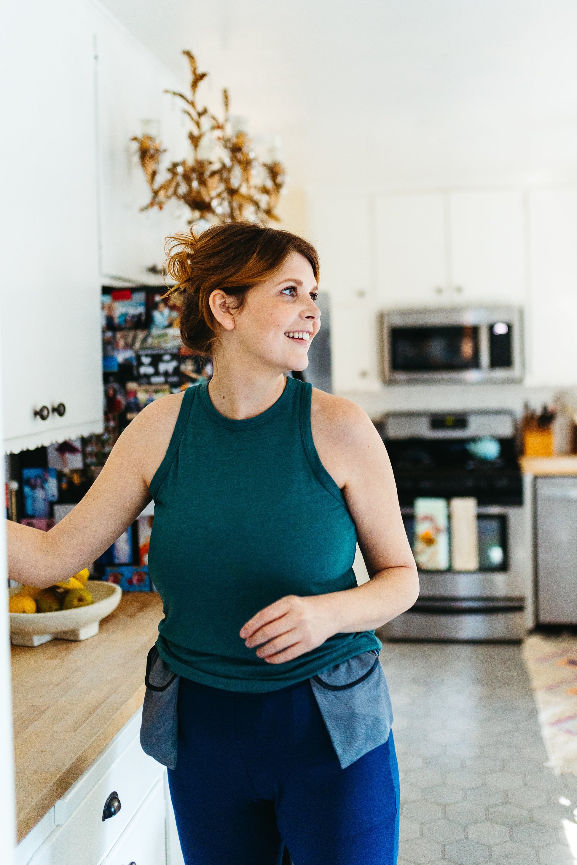 Woman wearing drain holder happily makes dinner in the kitchen