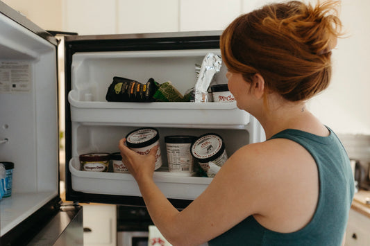 Woman removes ice from freezer following mastectomy surgery. 