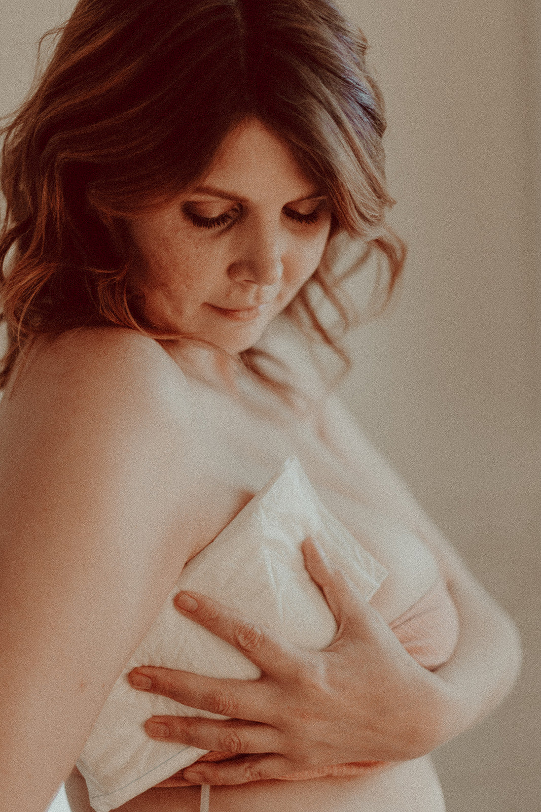 Woman holding an ABD dressing pad comfortably over her fresh mastectomy incision site.