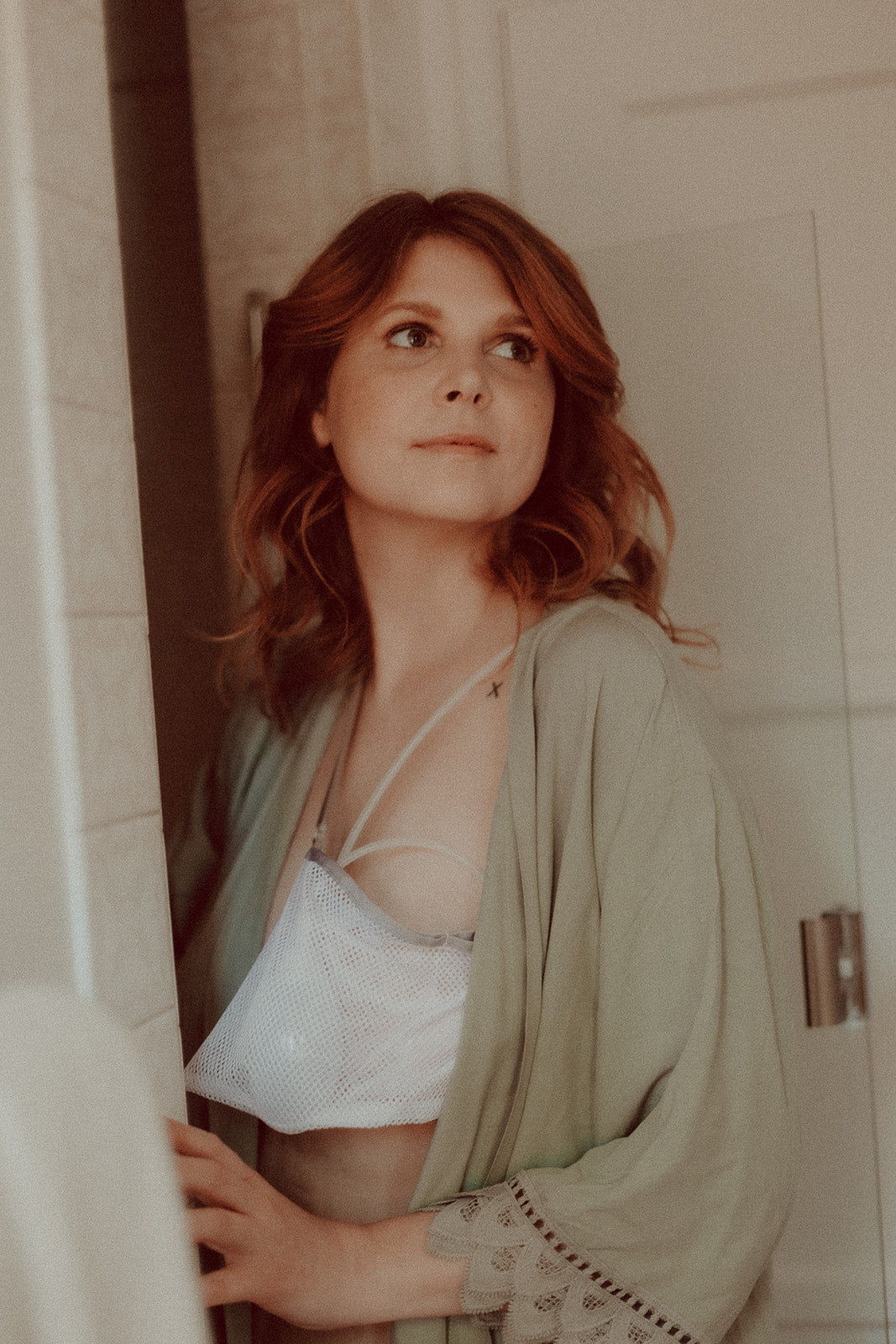 Woman preparing to get in to the shower with her mastectomy drains safely secured in a shower friendly drainage bag holder.